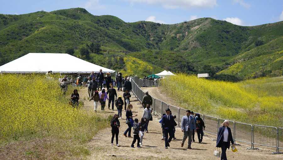 Attendees walk on a hiking path during a ground breaking ceremony for the Wallis Annenberg Wildlife Crossing Friday, April 22, 2022, in Agoura Hills, Calif. Construction has begun on what&apos;s billed as the world&apos;s largest wildlife crossing for mountain lions and other animals caught in Southern California&apos;s urban sprawl. Officials held a ceremony Friday to mark the construction of a $90 million bridge over the 101 freeway and feeder road near downtown Los Angeles. (AP Photo/Marcio Jose Sanchez)