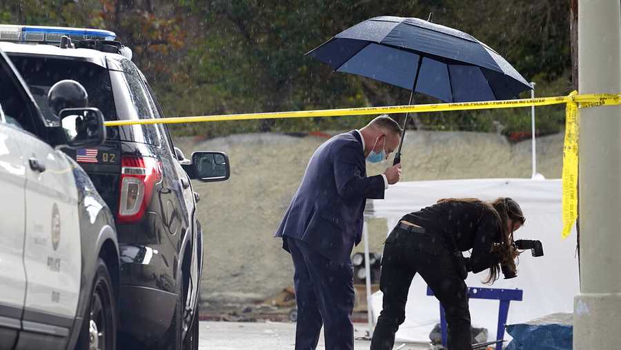 FILE - A Los Angeles Police investigator takes pictures in the rain, as investigators gather evidence in the death of an adult male found dead at a homeless encampment in downtown Los Angeles on March 12, 2021. A new report shows that nearly 2,000 homeless people died in Los Angeles County during the first year of the pandemic, an increase of 56% from the previous year, driven mainly by drug overdoses. The findings released Friday, April 22, 2022, in a report from the county&apos;s Department of Public Health are the latest illustration of how the COVID-19 pandemic impacted California&apos;s staggering population of unhoused people. (AP Photo/Damian Dovarganes, File)