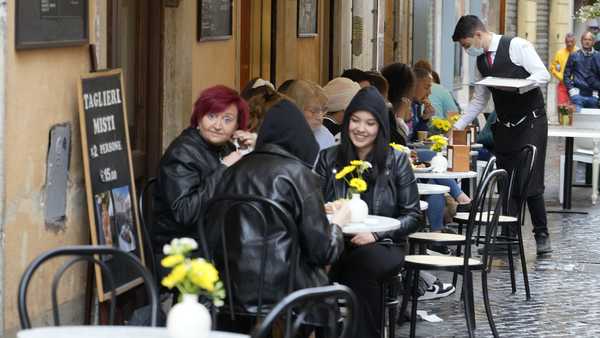 People gather at a bar in Rome, Sunday, May 1, 2022. Face masks, for the first time since the start of the pandemic, are no longer required in supermarkets, bars, restaurants, shops and most workplaces throughout Italy, but remain mandatory on public transport, planes, trains and ships, theatres, cinemas, concert halls and for indoor sporting events. (AP Photo/Gregorio Borgia)