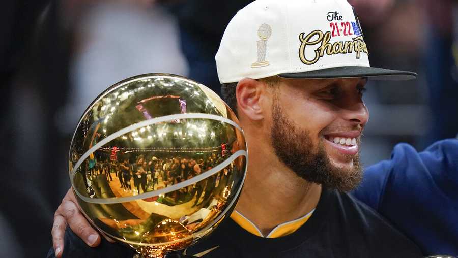 Golden State Warriors guard Stephen Curry, center, celebrates with teammates as he holds the Larry O&apos;Brien Trophy after the Warriors beat the Boston Celtics in Game 6 to win basketball&apos;s NBA Finals, Thursday, June 16, 2022, in Boston. (AP Photo/Steven Senne)