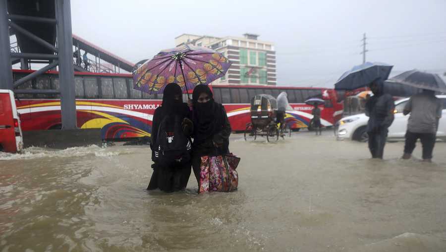 People wade through flooded waters in Bangladesh