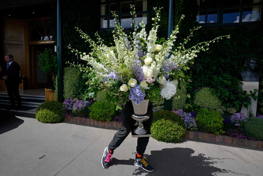 Wimbledon Tennis Week One Photo Gallery A member of the ground staff moves some flowers ahead of the Wimbledon tennis championships in London, Sunday, June 26, 2022.