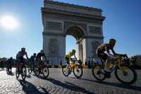 FILE - Denmark's Jonas Vingegaard, wearing the overall leader's yellow jersey, passes Arc de Triomphe during the twenty-first stage of the Tour de France cycling race over 116 kilometers (72 miles) with start in Paris la Defense Arena and finish on the Champs Elysees in Paris, France, Sunday, July 24, 2022.