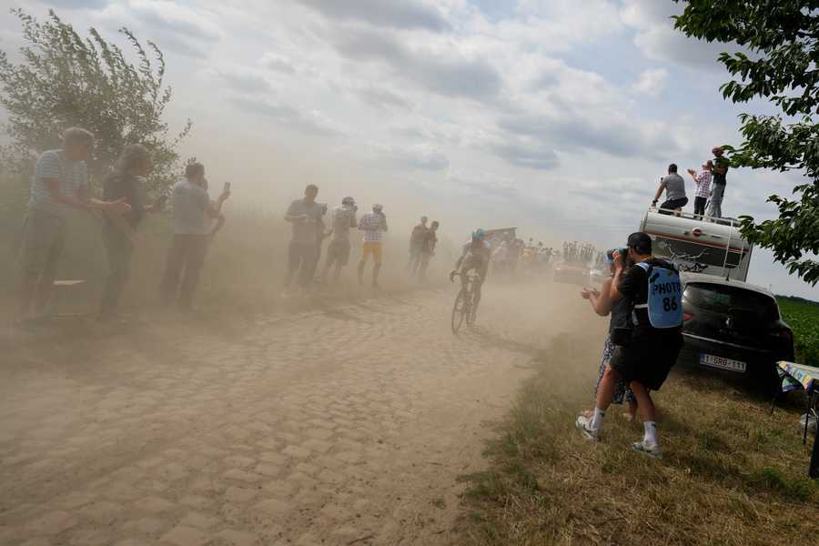 Riders pass over the cobblestones during the fifth stage of the Tour de France cycling race over 157 kilometers (97.6 miles) with start in Lille Metropole and finish in Arenberg Porte du Hainaut, France, Wednesday, July 6, 2022.