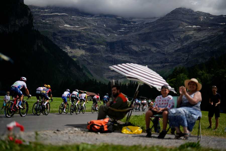 Spectators watch the breakaway group pass during the ninth stage of the Tour de France cycling race over 193 kilometers (119.9 miles) with start in Aigle, Switzerland and finish in Chatel les Portes du Soleil, France, Sunday, July 10, 2022.