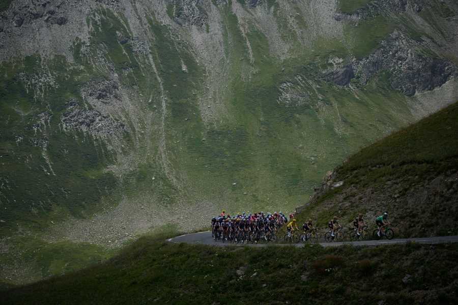 The pack with Denmark's Jonas Vingegaard, wearing the overall leader's yellow jersey, and Belgium's Wout Van Aert, wearing the best sprinter's green jersey, and his teammates set the pace for the pack as they climb Col du Galibier pass during the twelfth stage of the Tour de France cycling race over 165.5 kilometers (102.8 miles) with start in Briancon and finish in Alpe d'Huez, France, Thursday, July 14, 2022.