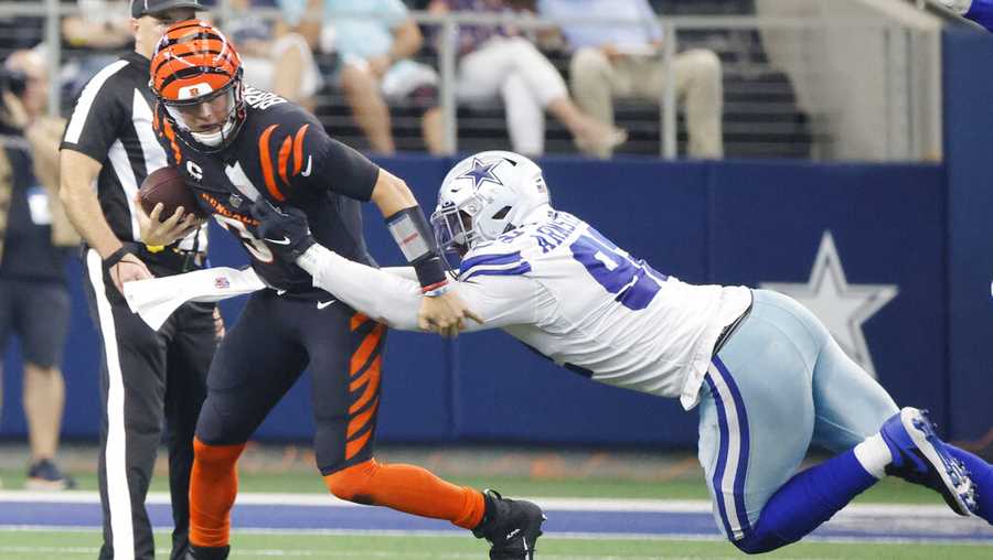 Cincinnati Bengals quarterback Joe Burrow (9) tries to avoid the sack of Dallas Cowboys defensive end Dorance Armstrong (92) during the first half of an NFL football game Sunday, Sept. 18, 2022, in Arlington, Tx. (AP Photo/Michael Ainsworth)