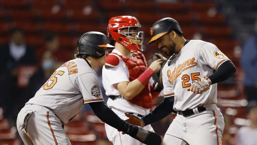 Baltimore Orioles&apos; Anthony Santander (25) celebrates after his two-run home run that also drove in Adley Rutschman, left, as Boston Red Sox&apos;s Reese McGuire, center, looks on during the seventh inning of a baseball game, Monday, Sept. 26, 2022, in Boston. (AP Photo/Michael Dwyer)