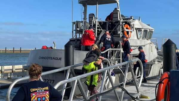 A Coast Guard Station Chincoteague 47-foot Motor Life Boat crew safely transfers 12 people ashore at the station on Friday, Oct. 28, 2022 in Chincoteague, Va. Thirteen people were rescued from a sinking fishing vessel early Friday more than 60 miles (96 kilometers) off the coast of Virginia, according to the U.S. Coast Guard.