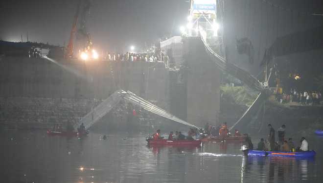 Rescuers&#x20;on&#x20;boats&#x20;search&#x20;in&#x20;the&#x20;Machchu&#x20;river&#x20;next&#x20;to&#x20;a&#x20;cable&#x20;bridge&#x20;that&#x20;collapsed&#x20;in&#x20;Morbi&#x20;town&#x20;of&#x20;western&#x20;state&#x20;Gujarat,&#x20;India,&#x20;Monday,&#x20;Oct.&#x20;31,&#x20;2022.&#x20;The&#x20;century-old&#x20;cable&#x20;suspension&#x20;bridge&#x20;collapsed&#x20;into&#x20;the&#x20;river&#x20;Sunday&#x20;evening,&#x20;sending&#x20;hundreds&#x20;plunging&#x20;in&#x20;the&#x20;water,&#x20;officials&#x20;said.&#x20;&#x28;AP&#x20;Photo&#x2F;Ajit&#x20;Solanki&#x29;