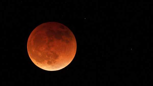 FILE - The moon is shown during a full lunar eclipse, Sunday, May 15, 2022, near Moscow, Idaho, with the reddish color caused by it passing into the shadow of the Earth. A Tuesday, Nov. 8, 2022 total lunar eclipse will be visible throughout North America in the predawn hours _ the farther west, the better _ and across Asia, Australia and the rest of the Pacific after sunset. (AP Photo/Ted S. Warren, File)