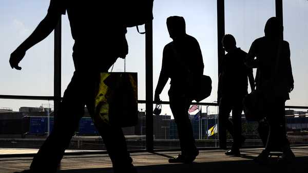 File - Arriving passengers move toward the baggage claim area at Philadelphia International Airport in Philadelphia on Friday, July 1, 2022. Travelers will probably pay more for airline tickets or a hotel room around the holidays than they did over last Thanksgiving or Christmas. (AP Photo/Matt Rourke, File)