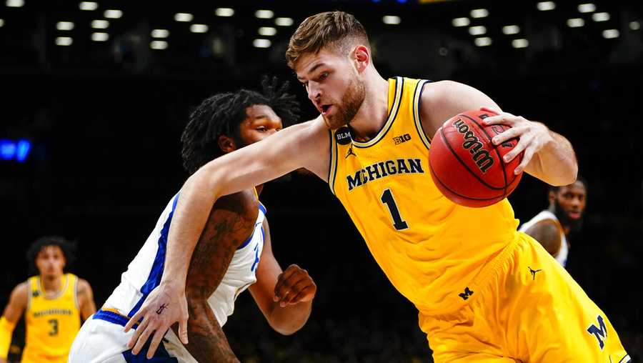 Michigan&apos;s Hunter Dickinson, right, drives past Pittsburgh&apos;s John Hugley IV during the first half of an NCAA basketball game at the Legends Classic Wednesday, Nov. 16, 2022, in New York. (AP Photo/Frank Franklin II)