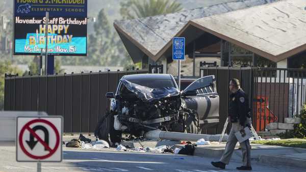 An investigator walks past a mangled SUV that struck Los Angeles County sheriff's recruits in Whittier, Calif., Wednesday, Nov. 16, 2022.