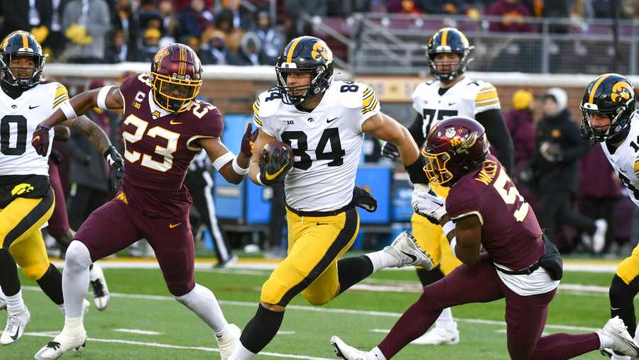 Iowa tight end Sam LaPorta (84) takes a short pass upfield past Minnesota defensive backs Jordan Howden (23) and Justin Walley (5) during the first half an NCAA college football game on Saturday, Nov. 19, 2022, in Minneapolis. (AP Photo/Craig Lassig)