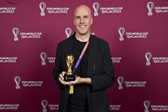 Grant&#x20;Wahl&#x20;smiles&#x20;as&#x20;he&#x20;holds&#x20;a&#x20;World&#x20;Cup&#x20;replica&#x20;trophy&#x20;during&#x20;an&#x20;award&#x20;ceremony&#x20;in&#x20;Doha,&#x20;Qatar&#x20;on&#x20;Nov.&#x20;29,&#x20;2022.&#x20;Wahl,&#x20;one&#x20;of&#x20;the&#x20;most&#x20;well-known&#x20;soccer&#x20;writers&#x20;in&#x20;the&#x20;United&#x20;States,&#x20;died&#x20;early&#x20;Saturday&#x20;Dec.&#x20;10,&#x20;2022&#x20;while&#x20;covering&#x20;the&#x20;World&#x20;Cup&#x20;match&#x20;between&#x20;Argentina&#x20;and&#x20;the&#x20;Netherlands.&#x20;&#x28;Brendan&#x20;Moran,&#x20;FIFA&#x20;via&#x20;AP&#x29;