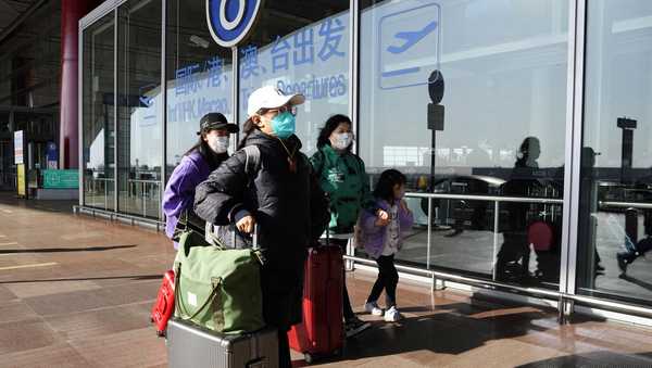 FILE - Passengers wearing masks walk through the Capital airport terminal in Beijing on Dec. 13, 2022. On Wednesday, Dec. 28, 2022, the U.S. announced new COVID-19 testing requirements for all travelers from China, joining other nations imposing restrictions because of a surge of infections. (AP Photo/Ng Han Guan, File)