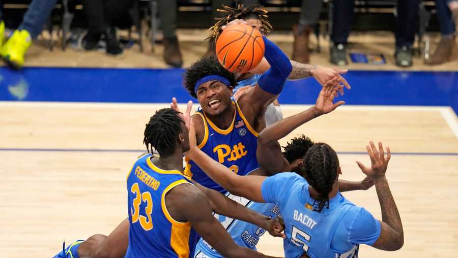 Pittsburgh forward Blake Hinson, center, is fouled as he goes to the basket during the second half of an NCAA college basketball game against North Carolina in Pittsburgh, Friday, Dec. 30, 2022. Pittsburgh won 76-74.