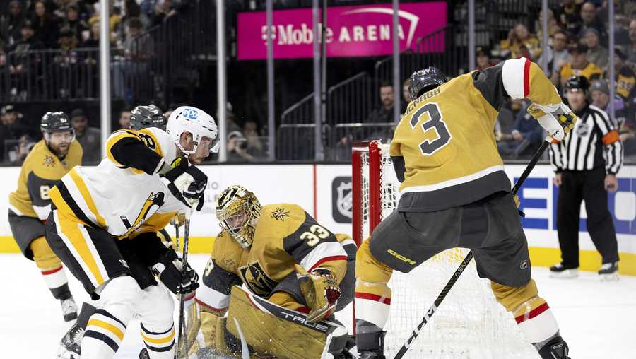 Vegas Golden Knights goaltender Adin Hill (33) makes a save on Pittsburgh Penguins defenseman Brian Dumoulin (8) while Vegas Golden Knights defenseman Brayden McNabb (3) defends during the first period of an NHL hockey game Thursday, Jan. 5, 2023, in Las Vegas.
