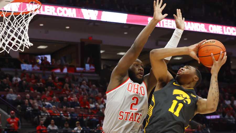 Iowa&apos;s Tony Perkins, right, tries to shoot over Ohio State&apos;s Bruce Thornton during the first half of an NCAA college basketball game on Saturday, Jan. 21, 2023, in Columbus, Ohio. (AP Photo/Jay LaPrete)