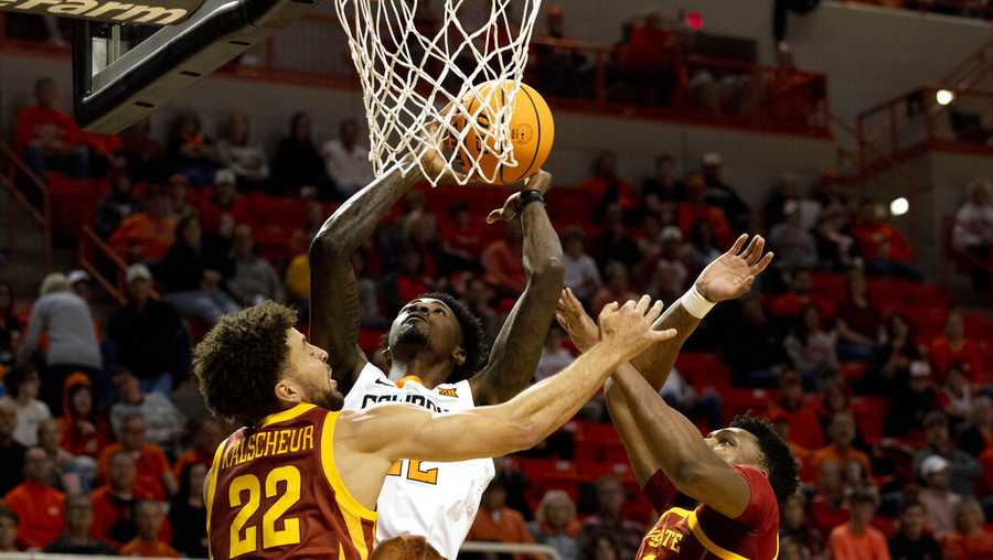 Oklahoma State&apos;s Kalib Boone (22) shoots over Iowa State&apos;s Gabe Kalscheur (22) and Osun Osunniyi (21) during the first half of the NCAA college basketball game in Stillwater, Okla., Saturday, Jan. 21, 2023. (AP Photo/Mitch Alcala)