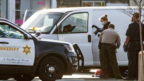 A body is seen on the driver's side of a van as authorities investigate, in Torrance, Calif., Sunday, Jan. 22, 2023. Authorities say the driver, the suspect in a California dance club shooting that left multiple people dead, shot and killed himself. (AP Photo/Damian Dovarganes)