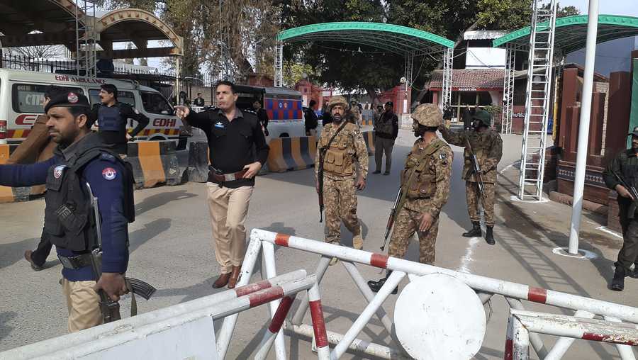 Army soldiers and police officers clear the way for ambulances rushing toward a bomb explosion site, at the main entry gate of police offices, in Peshawar, Pakistan, Monday, Jan. 30, 2023. A powerful bomb went off Monday near a mosque and police offices in the northwestern Pakistani city of Peshawar, police and government officials said.
