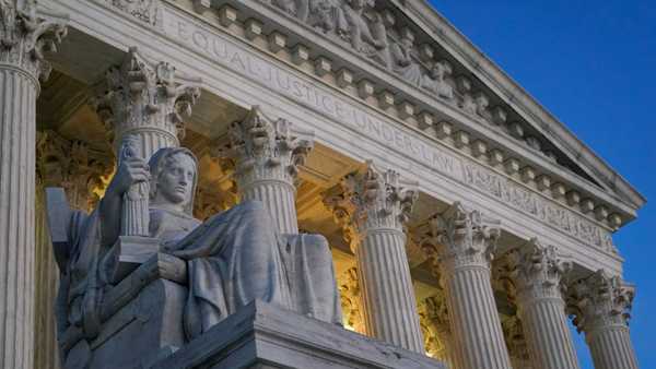 FILE- Light illuminates part of the Supreme Court building on Capitol Hill in Washington, Nov. 16, 2022. The Supreme Court is about to hear arguments over President Joe Biden's student debt relief plan. It's a plan that impacts millions of borrowers who could see their loans wiped away or reduced.