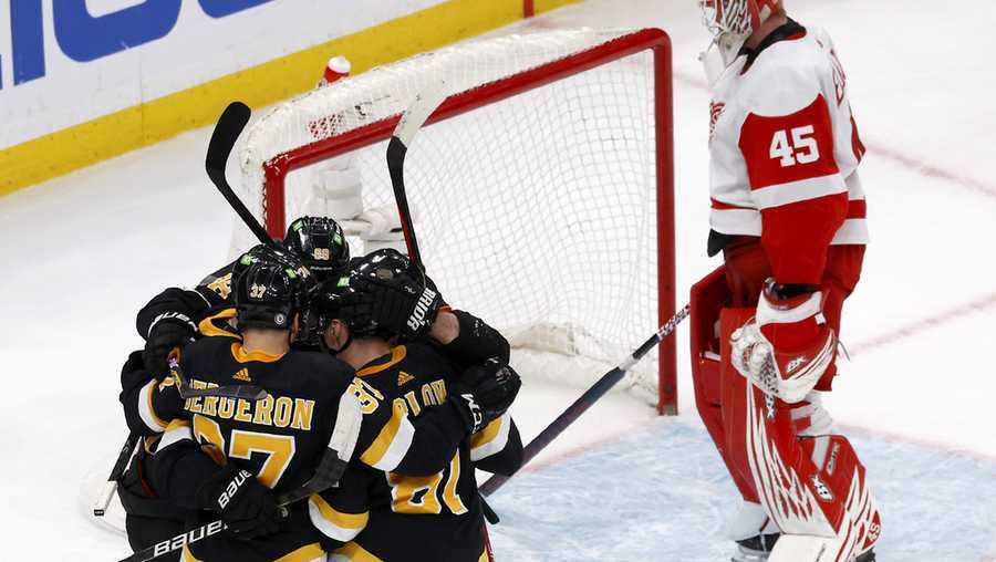 Boston Bruins players congratulate Patrice Bergeron (37) after he scored a goal past Detroit Red Wings goaltender Magnus Hellberg (45) during the second period of an NHL hockey game, Saturday, March 11, 2023, in Boston. (AP Photo/Mary Schwalm)
