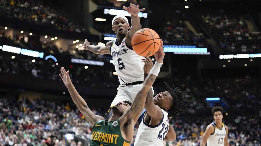March Madness Vermont guard Aaron Deloney (1) tries to shoot on Marquette guard Chase Ross (5) and Sean Jones (22) in the second half of a first-round college basketball game in the NCAA Tournament Friday, March 17, 2023, in Columbus, Ohio. (AP Photo/Paul Sancya)