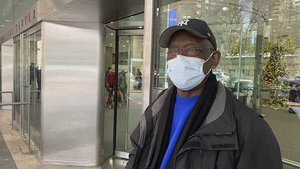 CORRECTS TO FRANK COPE, NOT TAIKWAN WRIGHT - Frank Cope waits outside for a car after a checkup at Bellevue Hospital in New York on Wednesday, Jan. 3, 2023. The previous week, New York City resumed a mask mandate for the city's 11 public hospitals. (AP Photo/Mary Conlon)