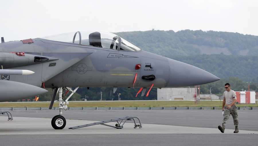 A Massachusetts Air National Guard aircraft maintainer walks past an F-15C fighter aircraft at Barnes Air National Guard Base, in Westfield, Mass., Wednesday, Aug. 27, 2014. An experienced pilot on a standard maintenance mission was missing Wednesday after his fighter jet crashed in the mountains of western Virginia. (AP Photo/Steven Senne)