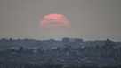 The sun sets behind buildings that were destroyed during the Israeli ground and air operations stand in the northern Gaza Strip as seen from southern Israel, Friday, Aug. 8, 2025. (AP Photo/Leo Correa)