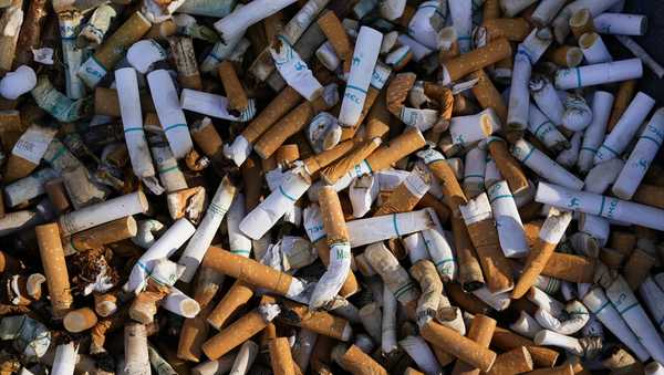 Cigarette butts fill a smoking receptacle outside a federal building in Washington, Thursday, April 15, 2021. According to government survey data released Thursday, April 27, 2023, U.S. adults are smoking less. Cigarette smoking dropped to another new all-time low in 2022, with 1 in 9 adults saying they were current smokers. Meanwhile, e-cigarette use rose, to about 1 in 17 adults. (AP Photo/J. Scott Applewhite, File)