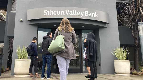 File - People stand outside a Silicon Valley Bank branch in Santa Clara, Calif., Friday, March 10, 2023. The Federal Reserve is scheduled Friday to release a highly-anticipated review of its supervision of Silicon Valley Bank, the go-to bank for venture capital firms and technology start-ups that failed spectacularly in March. (AP Photo/Jeff Chiu, File)