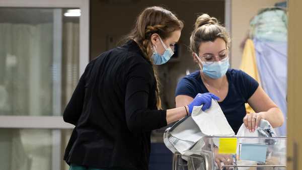 In a photo provided by the University of Vermont Health Network, licensed nursing assistant Jordan Bushy, right, and a student nurse care for newborns at the University of Vermont Children's Hospital in Burlington, Vt., Friday, April 28, 2023.