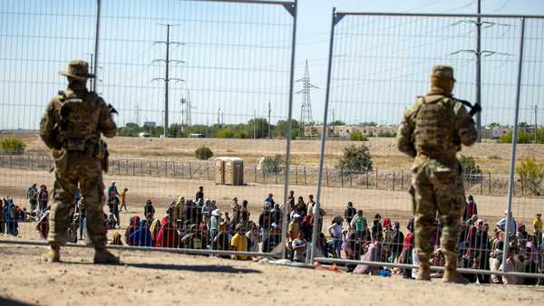 FILE - Migrants wait in line adjacent to the border fence under the watch of the Texas National Guard to enter into El Paso, Texas, Wednesday, May 10, 2023. U.S. authorities say an 8-year-old girl died Wednesday, May 17, in Border Patrol custody, a rare occurrence that comes as the agency struggles with overcrowding. The Border Patrol had 28,717 people in custody on May 10, the day before pandemic-related asylum restrictions expired, which was double from two weeks earlier, according to a court filing.