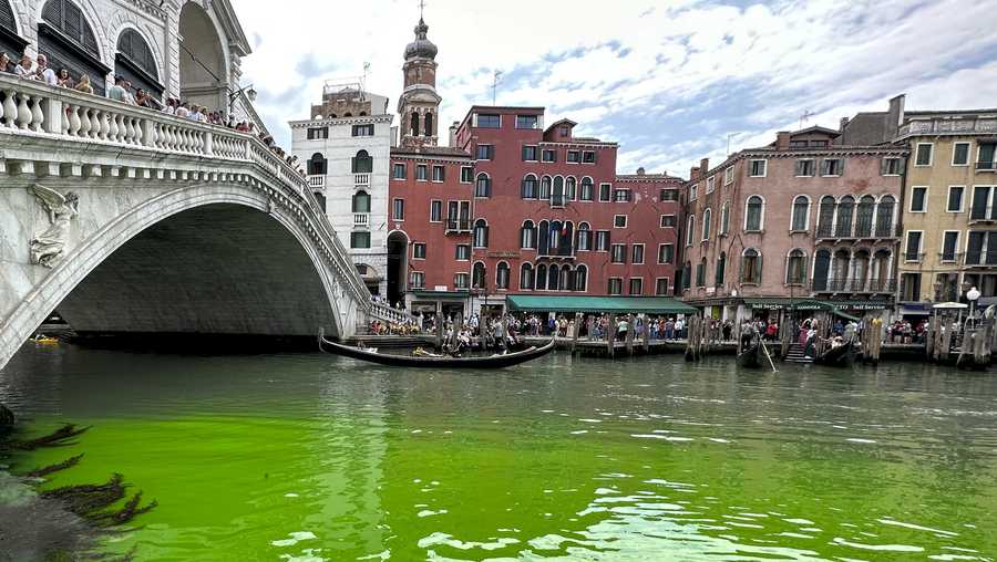 Gondolas navigate by the Rialto Bridge on Venice&apos;s historical Grand Canal as a patch of phosphorescent green liquid spreads in it, Sunday, May 28, 2023. The governor of the Veneto region, Luca Zaia, said that officials had requested the police to investigate to determine who was responsible, as environmental authorities were also testing the water. (AP Photo/Luigi Costantini)