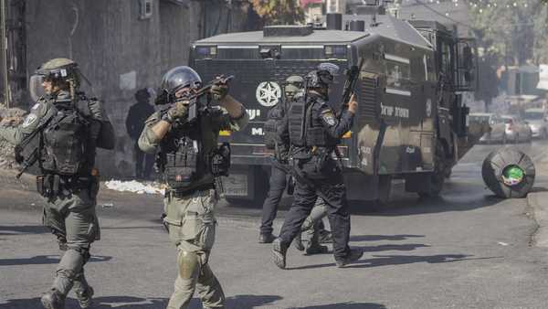 An Israeli security force member aims his gun during clashes with Palestinians in east Jerusalem, Friday, Oct. 13, 2023.
