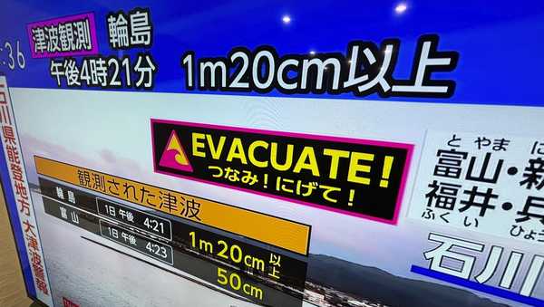 A tsunami warning is shown on TV in Yokohama, near Tokyo Monday, Jan. 1, 2024. Japan issued tsunami alerts Monday after a series of strong quakes in the Sea of Japan. (AP Photo/Eugene Hoshiko)