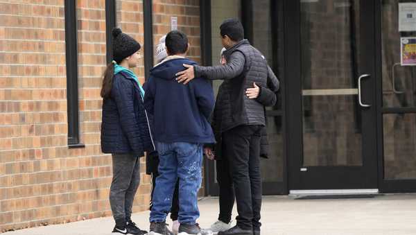 People embrace outside the McCreary Community Building where families are being reunited following a shooting at Perry High School, Thursday, Jan. 4, 2024, in Perry, Iowa. (AP Photo/Charlie Neibergall)