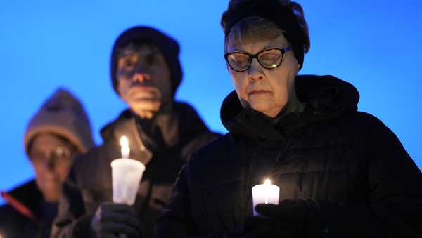 Local  residents pray during a candlelight vigil following a shooting at Perry High School, Thursday, Jan. 4, 2024, in Perry, Iowa. (AP Photo/Charlie Neibergall)