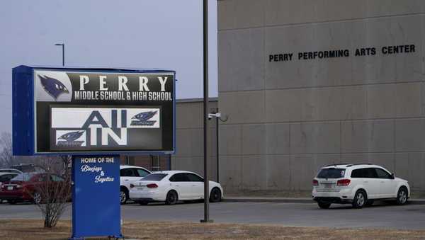 FILE - Vehicles are seen in a parking lot outside of Perry High School following a shooting at the school, Jan. 5, 2024, in Perry, Iowa. An Iowa principal who put himself in harm's way to protect students during a school shooting earlier this month died Sunday, Jan. 14, 2024, a funeral home confirmed. Caldwell Parrish Funeral Home & Crematory confirmed the death of Perry High School Principal Dan Marburger after the family announced it on a GoFundMe page. (AP Photo/Charlie Neibergall, file)