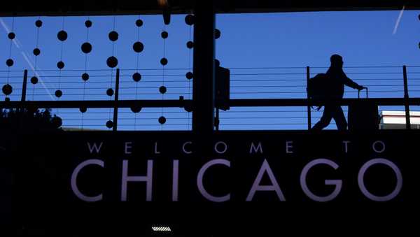 FILE - A passenger walks with luggage past holiday decorations at Chicago O'Hare International Airport, Dec. 24, 2022, in Chicago. A plane taxiing for departure clipped another aircraft at Chicago O'Hare International Airport on Sunday evening, Jan. 14, 2024, the Federal Aviation Administration said Monday, Jan. 15. (AP Photo/Paul Beaty, File)