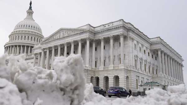 The U.S Capitol is photographed past piles of snow on Thursday, Jan. 18, 2024, in Washington. (AP Photo/Mariam Zuhaib)