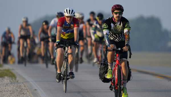 Cyclists make their way on a county highway while riding in The Des Moines Register's annual bike ride across Iowa, also known as RAGBRAI, Tuesday, July 25, 2023, near Scranton, Iowa. (AP Photo/Charlie Neibergall)