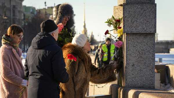 People lay flowers paying tribute to Alexei Navalny at the Memorial to Victims of Political Repression in St. Petersburg, Russia, Sunday, Feb. 18, 2024. Russians across the vast country streamed to ad-hoc memorials with flowers and candles to pay tribute to Alexei Navalny, the most famous Russian opposition leader and the Kremlin's fiercest critic. Russian officials reported that Navalny, 47, died in prison on Friday. (AP Photo/Dmitri Lovetsky)