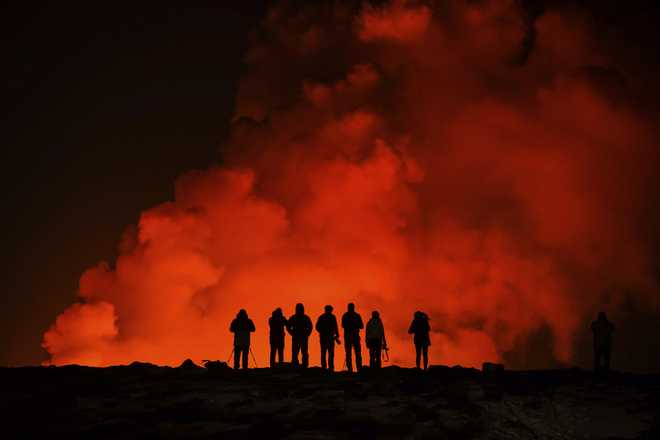 People&#x20;look&#x20;at&#x20;the&#x20;volcano&#x20;erupting,&#x20;north&#x20;of&#x20;Grindav&#x00ED;k,&#x20;Iceland,&#x20;Thursday,&#x20;Feb.&#x20;8,&#x20;2024.&#x20;Iceland&#x2019;s&#x20;Meteorological&#x20;Office&#x20;says&#x20;a&#x20;volcano&#x20;is&#x20;erupting&#x20;in&#x20;the&#x20;southwestern&#x20;part&#x20;of&#x20;the&#x20;country,&#x20;north&#x20;of&#x20;a&#x20;nearby&#x20;settlement.&#x20;The&#x20;eruption&#x20;of&#x20;the&#x20;Sylingarfell&#x20;volcano&#x20;began&#x20;at&#x20;6&#x20;a.m.&#x20;local&#x20;time&#x20;on&#x20;Thursday,&#x20;soon&#x20;after&#x20;an&#x20;intense&#x20;burst&#x20;of&#x20;seismic&#x20;activity.&#x20;&#x28;AP&#x20;Photo&#x2F;Marco&#x20;Di&#x20;Marco&#x29;