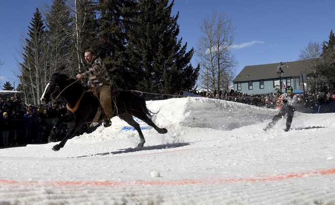 A&#x20;skijoring&#x20;team&#x20;competes&#x20;in&#x20;Leadville,&#x20;Colo.,&#x20;on&#x20;Saturday,&#x20;March&#x20;2,&#x20;2024.&#x20;Skijoring&#x20;draws&#x20;its&#x20;name&#x20;from&#x20;the&#x20;Norwegian&#x20;word&#x20;skikjoring,&#x20;meaning&#x20;&amp;quot&#x3B;ski&#x20;driving.&amp;quot&#x3B;&#x20;It&#x20;started&#x20;as&#x20;a&#x20;practical&#x20;mode&#x20;of&#x20;transportation&#x20;in&#x20;Scandinavia&#x20;and&#x20;became&#x20;popular&#x20;in&#x20;the&#x20;Alps&#x20;around&#x20;1900.&#x20;Today&amp;apos&#x3B;s&#x20;sport&#x20;features&#x20;horses&#x20;at&#x20;full&#x20;gallop&#x20;towing&#x20;skiers&#x20;by&#x20;rope&#x20;over&#x20;jumps&#x20;and&#x20;around&#x20;obstacles&#x20;as&#x20;they&#x20;try&#x20;to&#x20;lance&#x20;suspended&#x20;hoops&#x20;with&#x20;a&#x20;baton,&#x20;typically&#x20;a&#x20;ski&#x20;pole&#x20;that&amp;apos&#x3B;s&#x20;cut&#x20;in&#x20;half.&#x20;&#x28;AP&#x20;Photo&#x2F;Thomas&#x20;Peipert&#x29;