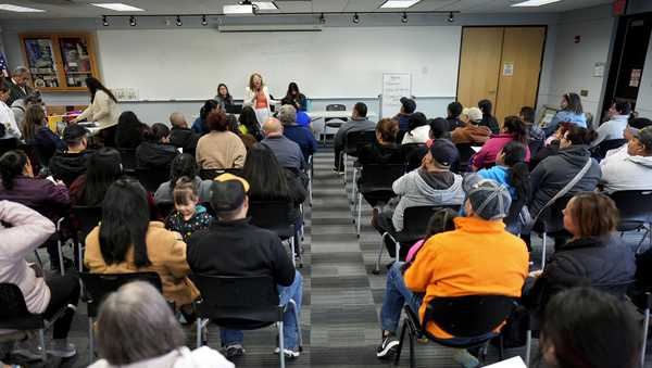 Audience members listen to community organizer Maria Acosta speak during an Iowa Migrant Movement for Justice informational meeting, Wednesday, March 27, 2024, in Des Moines, Iowa. A bill in Iowa that would allow the state to arrest and deport some migrants is stoking anxiety among immigrant communities about how it would be interpreted and enforced. (AP Photo/Charlie Neibergall)